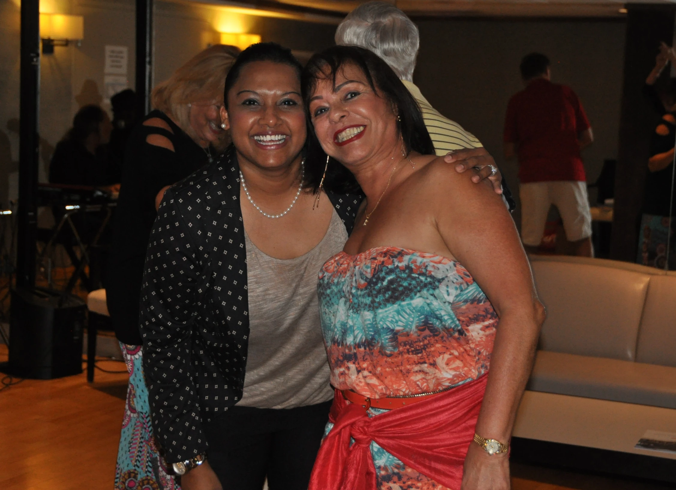 two women pose for the camera while at an event