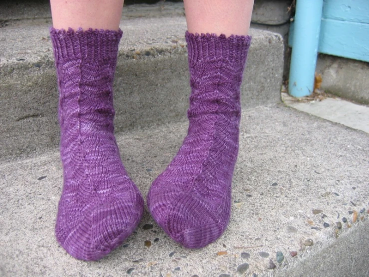 the person has purple socks on sitting on steps