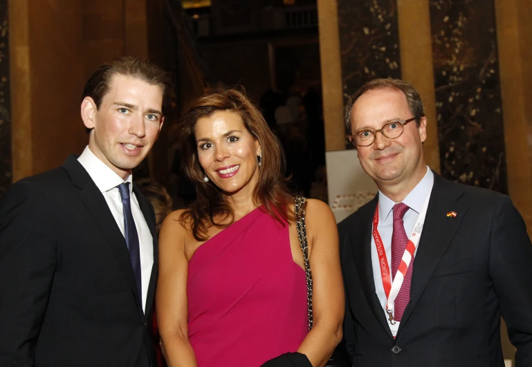 three people posing for a po at an event