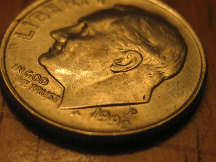 closeup of the back of a coin showing a face profile and some writing on it