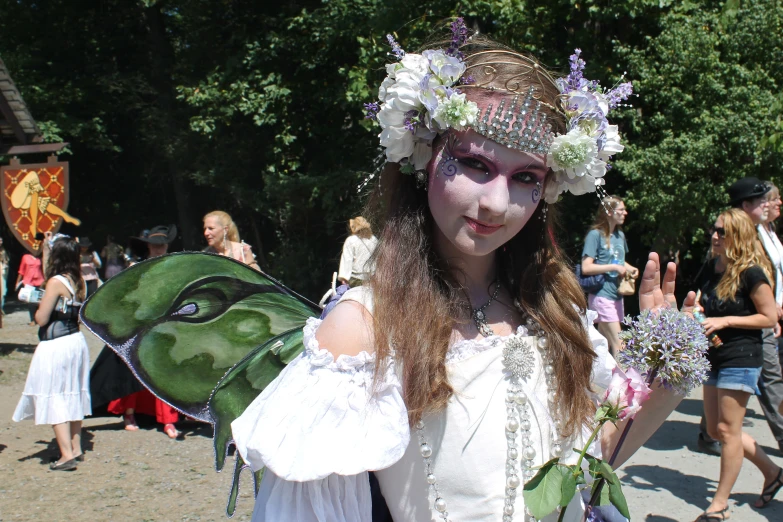 woman dressed in white and costume carrying a erfly