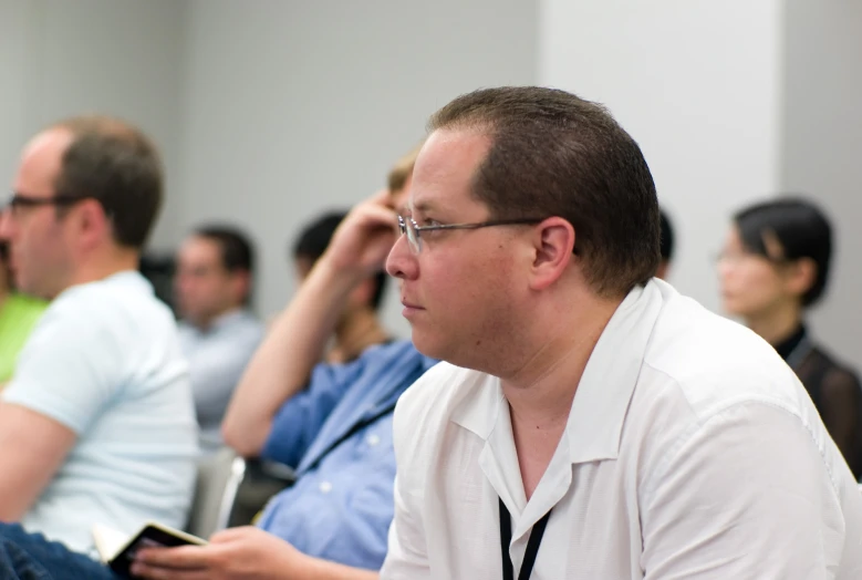 a man in glasses is listening to someone else