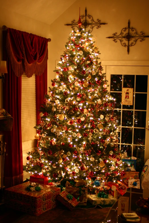 an illuminated christmas tree sitting in a living room