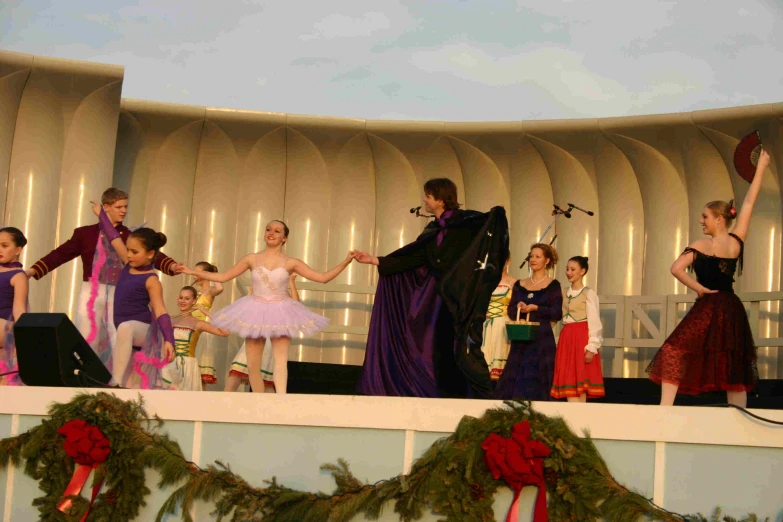 performers on stage with christmas wreaths in the background