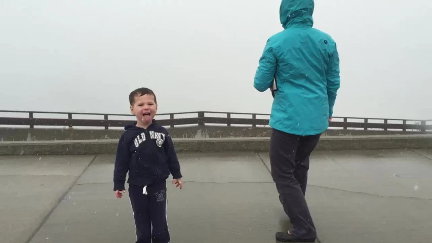 two boys standing near each other in the rain