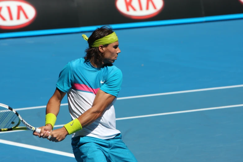 tennis player in blue holding a racquet on the court