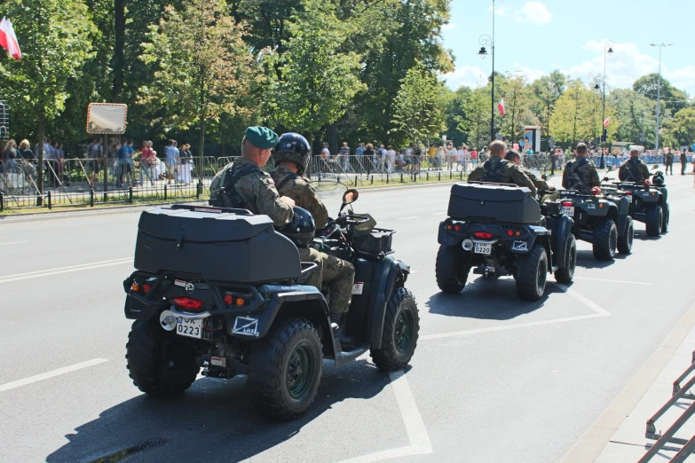 military motorcycle driving with another group in the back