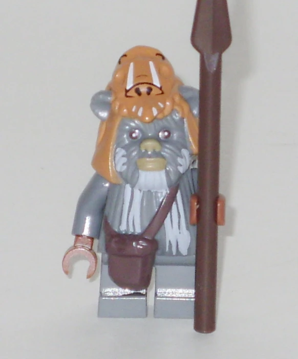 a lego character with a brown hat and orange beard, holding a shovel