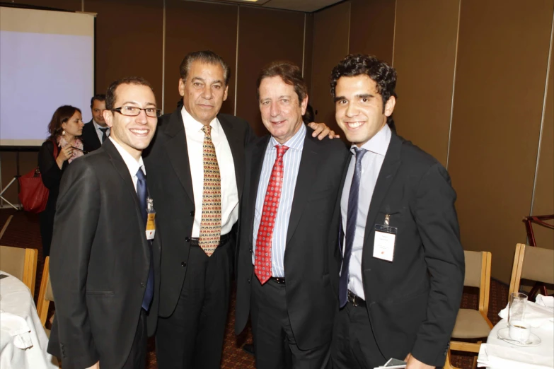 three men standing next to each other posing for the camera