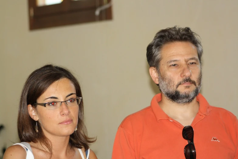 a man wearing glasses is standing next to a woman