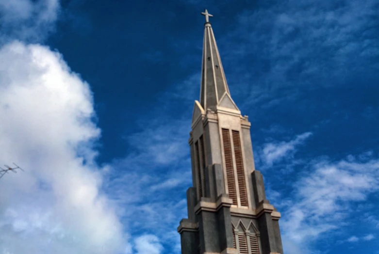 a clock tower with a cross on top