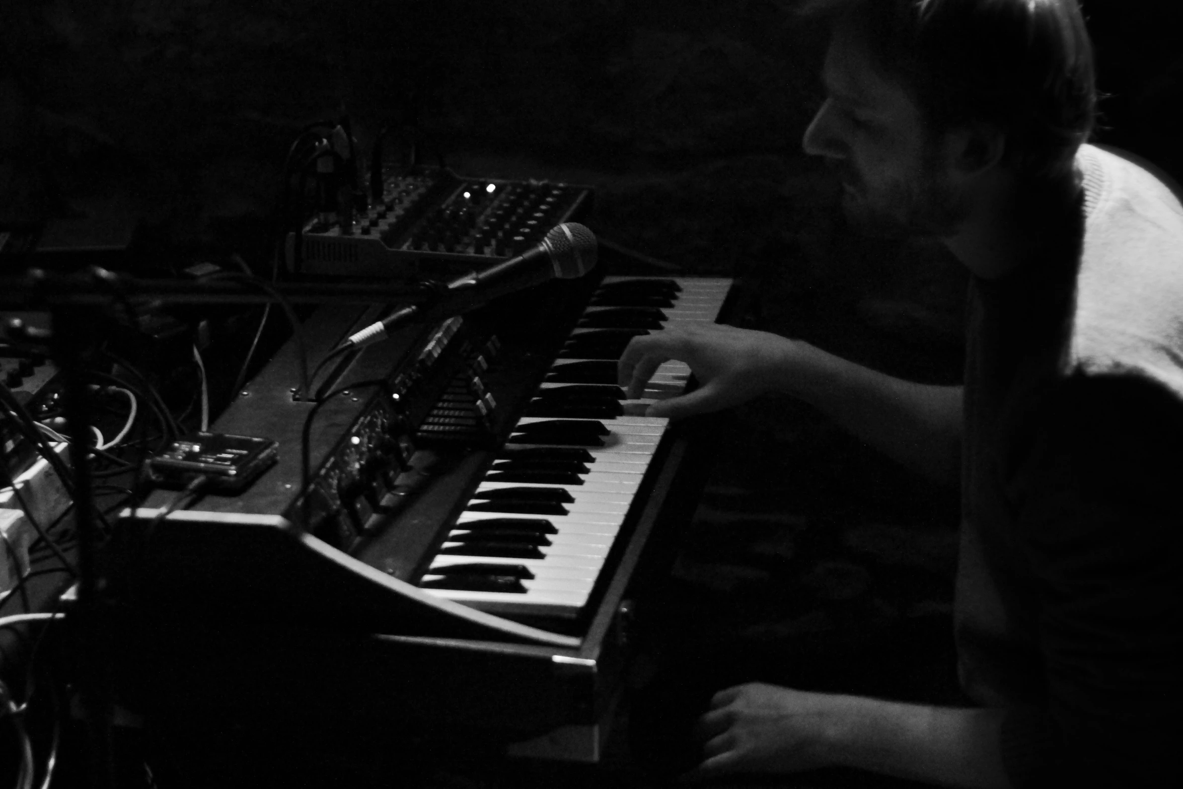 a man playing an electronic keyboard in the dark