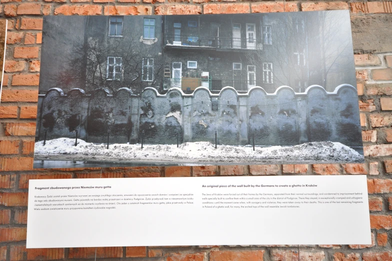 a brick wall with a large poster hanging on it