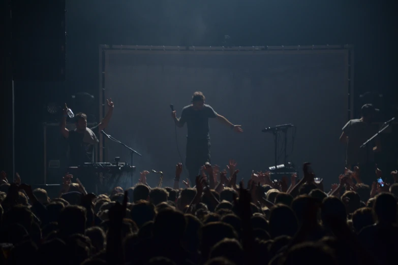 there is a man standing in front of the crowd with his arms outstretched