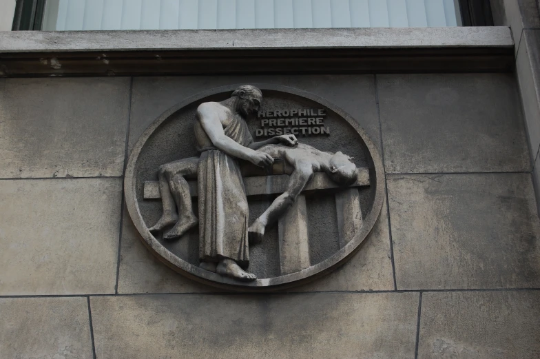 the statue is on the wall next to a building