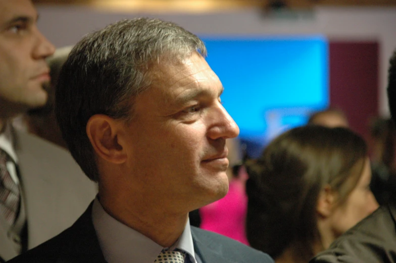 a man in a suit standing next to a man in a red tie