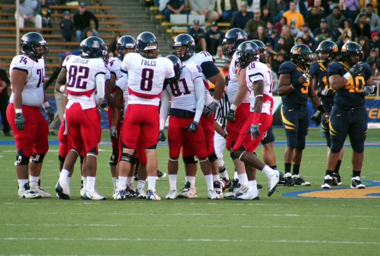 the football team stands in a group on the field