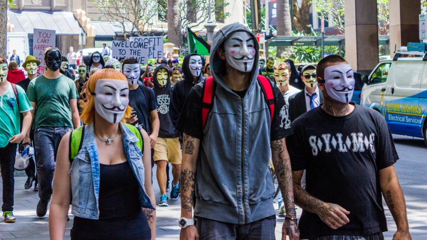 several people walking in a street with masks on