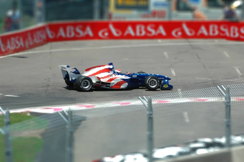 a blue race car races down the track