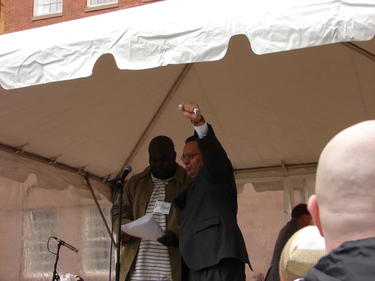 two men pointing at soing with their hands up