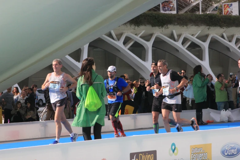 some people are running on a track near a crowd