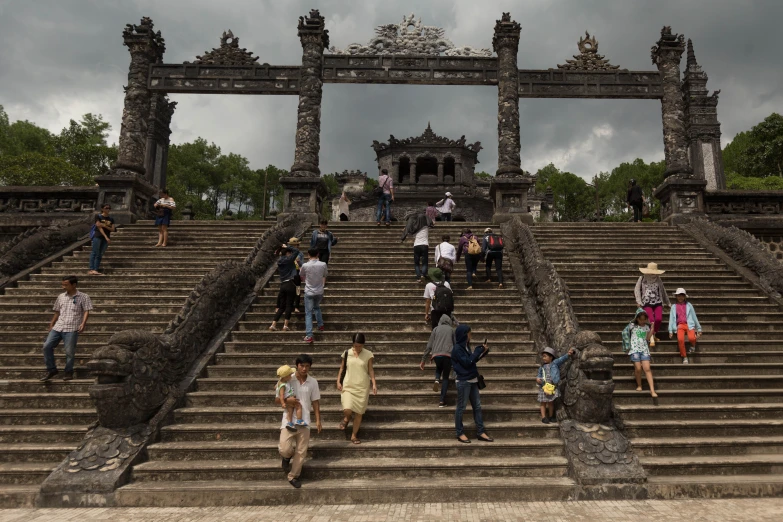 several tourists are on stone steps under an old archway