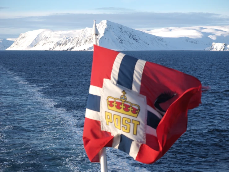 a british flag flying over a boat traveling through water