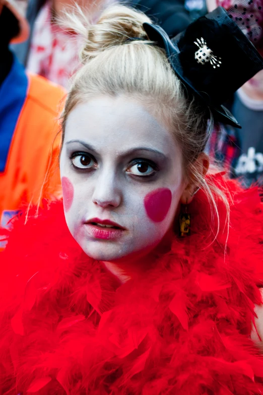 a girl wearing costume with red feathers and face paint