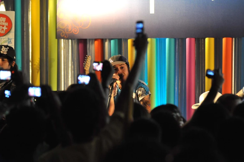 a man holding up his phone in front of a crowd