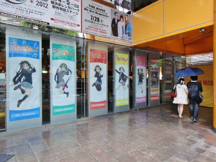 a woman walking down a sidewalk holding an umbrella