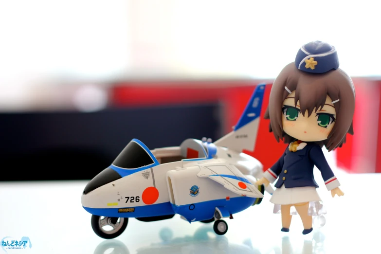 the small figurine depicts a female pilot from the anime