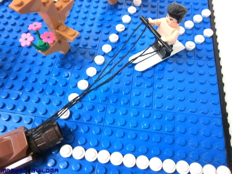 a lego figure being pulled by a boat