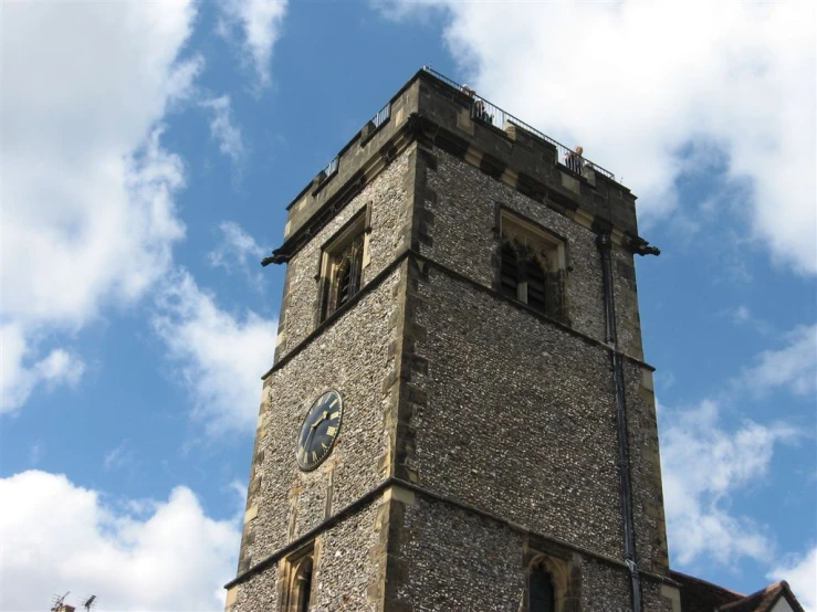 a tall tower with a clock sitting below clouds