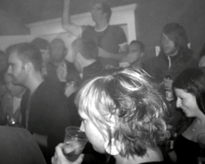 a black and white po shows many people at a bar