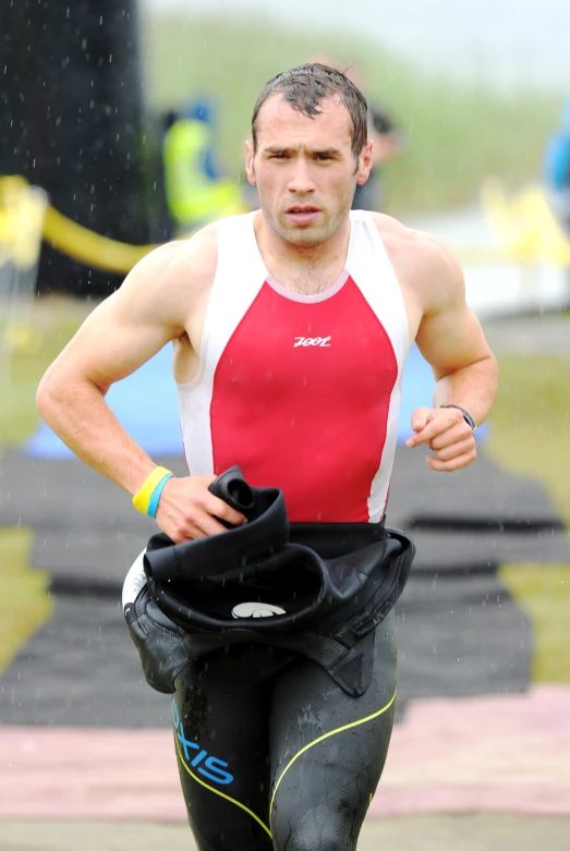 a man wearing red is running in the rain