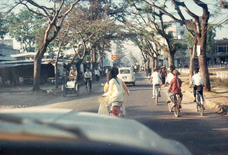 a bunch of people on bicycles are traveling down a road