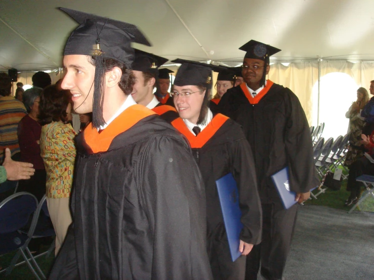 several students walking with their diplomas in hand