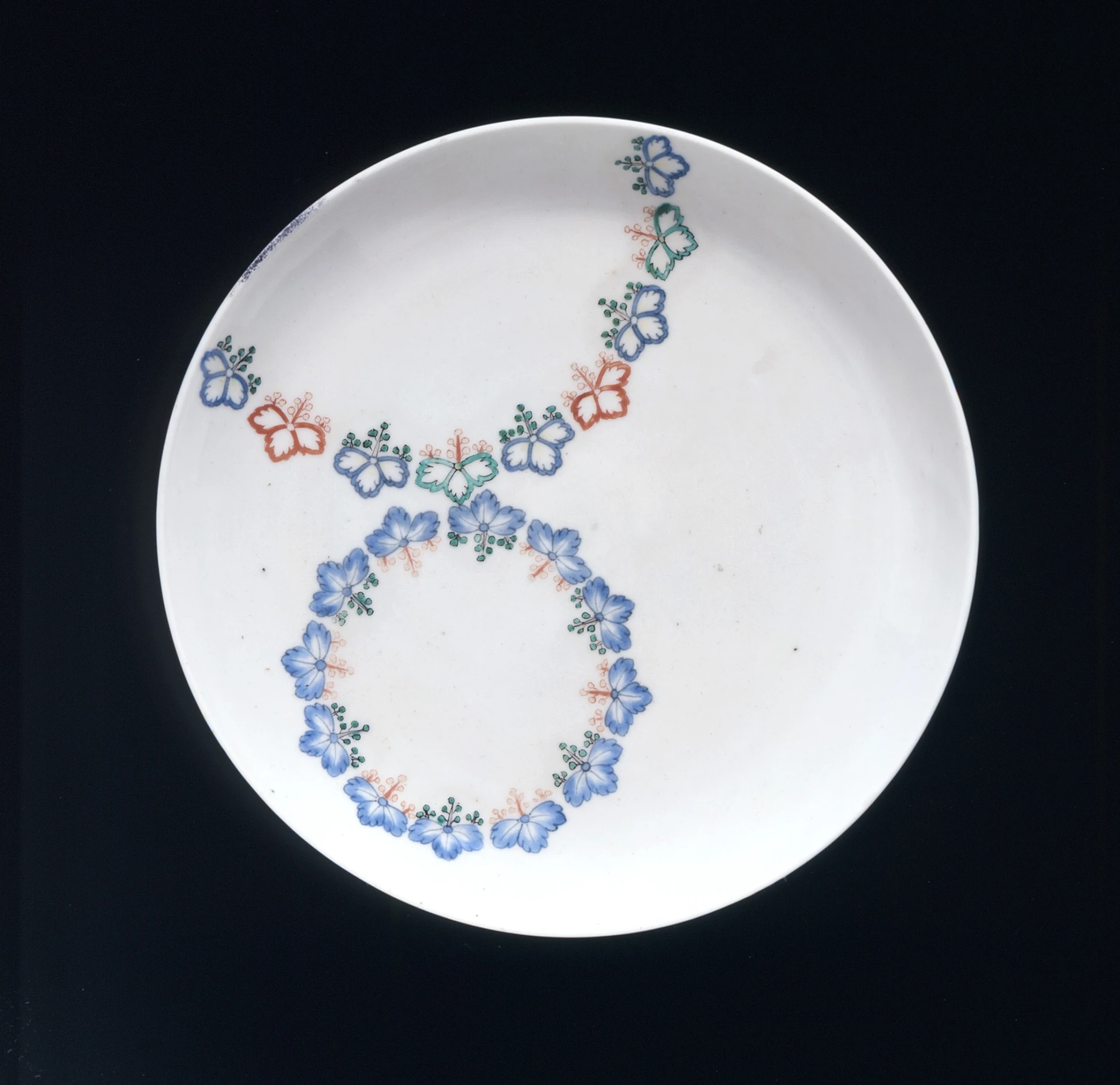 a white plate with an artisticly beaded necklace on it