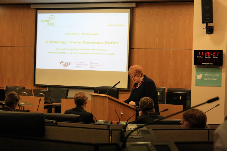 people in an auditorium with two men giving a presentation