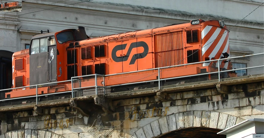 a red train that is on a track above some rocks