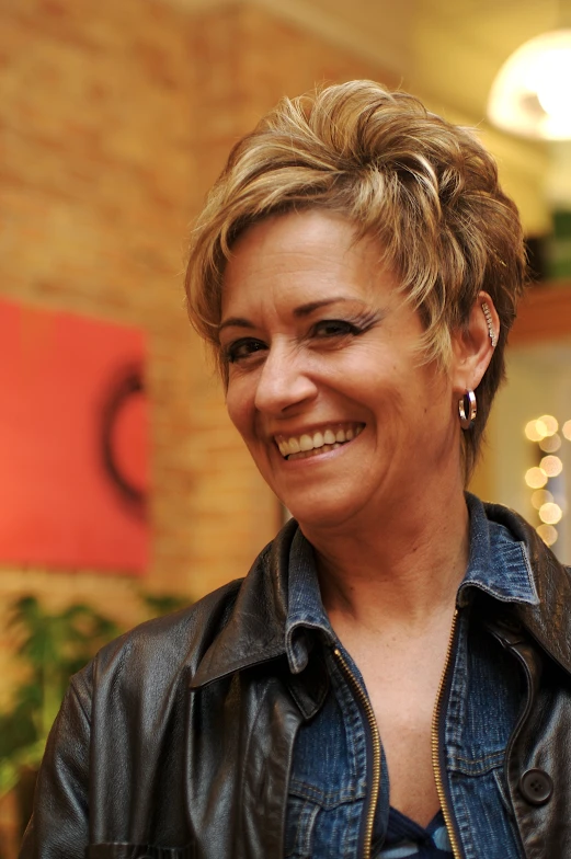 a smiling woman in a black leather jacket
