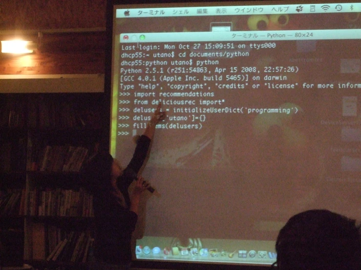someone pointing to an array on a big screen in a liry