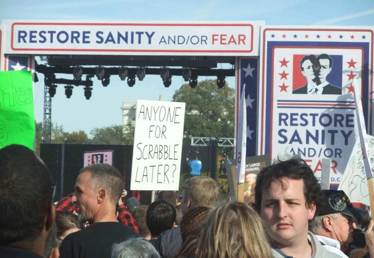 a man holding signs at a political rally