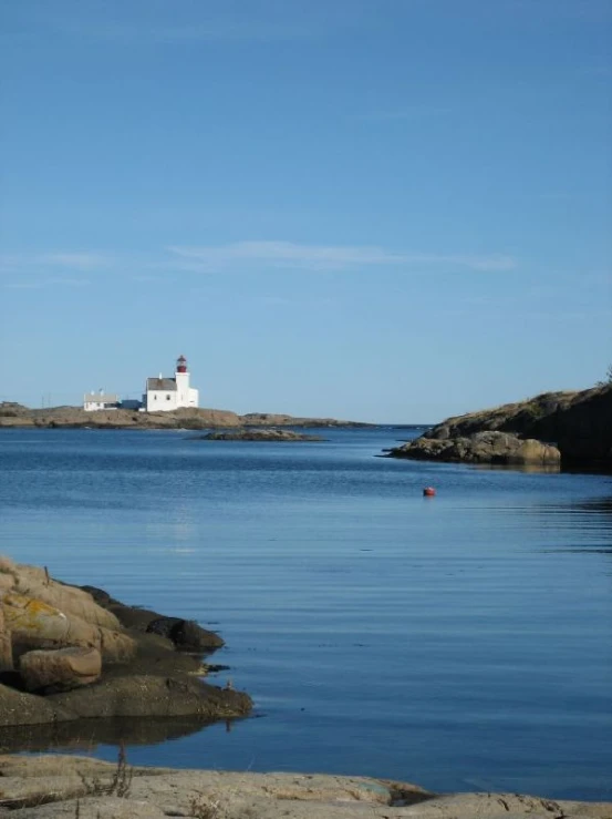 an image of a lighthouse setting on the water