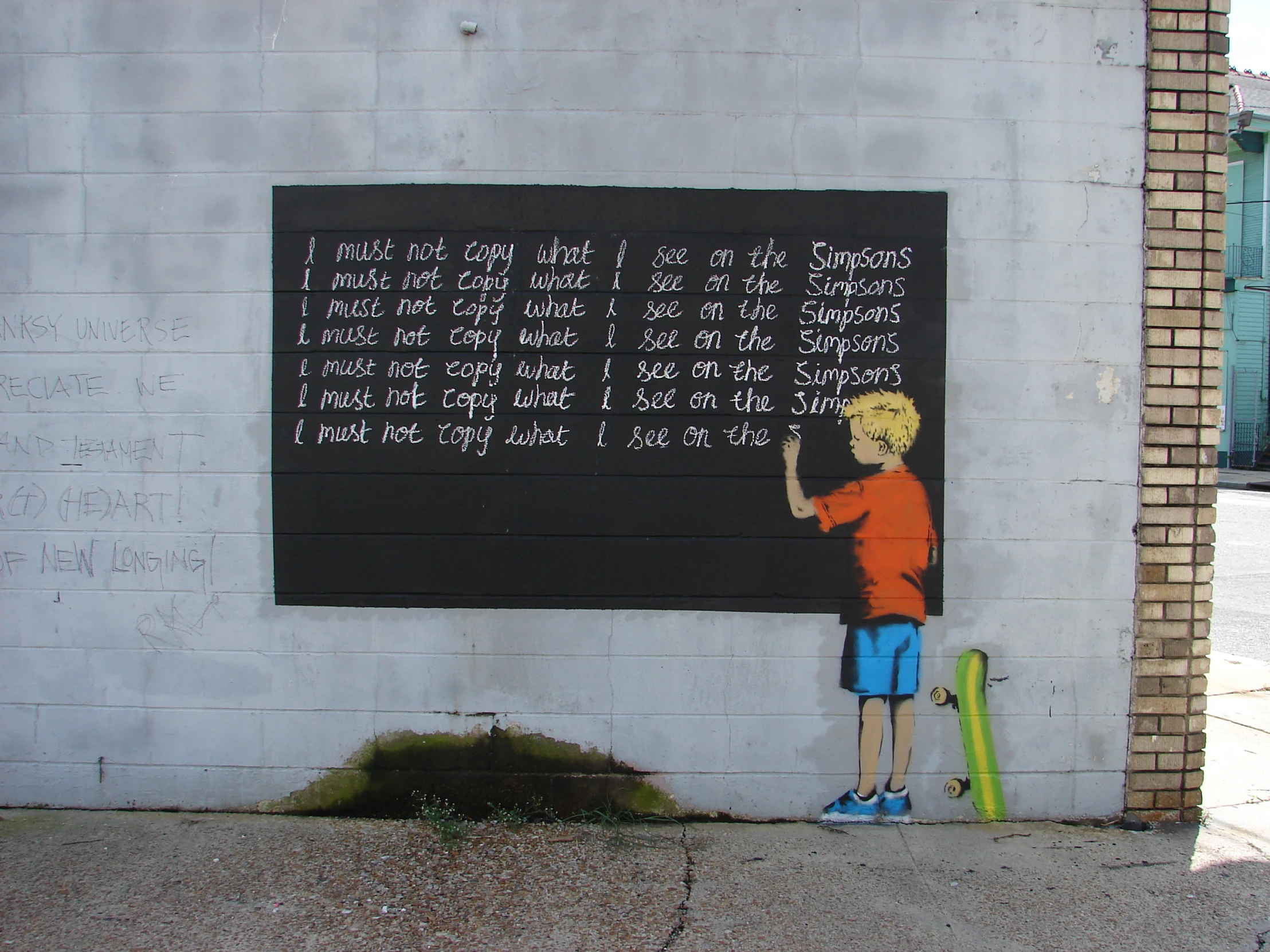 a boy writing on a large black chalkboard with chalk