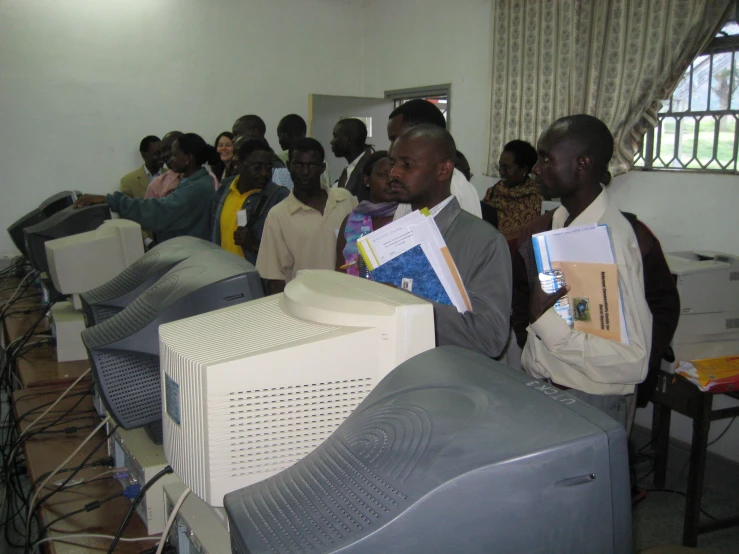 men in front of computer monitors and their papers