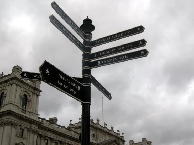 four signs are on a post in front of a building