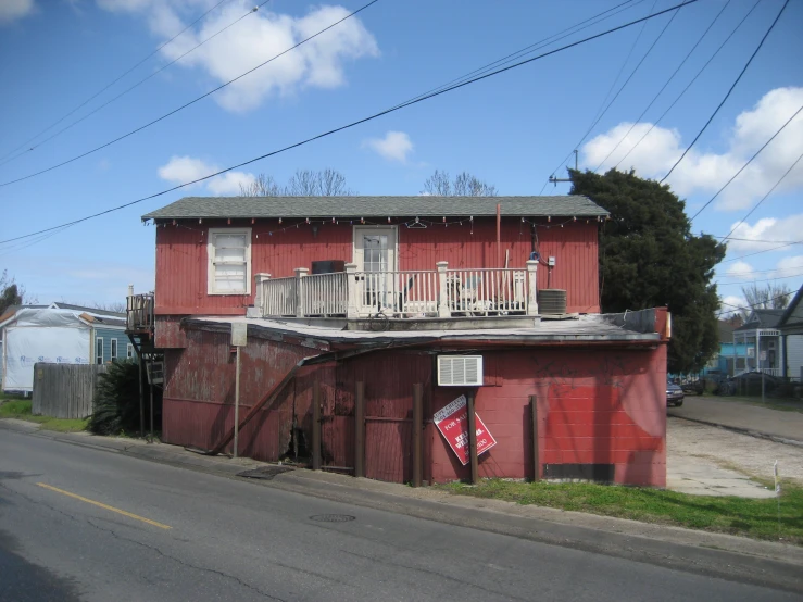 red building sitting on the side of a road next to a telephone pole