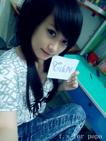 a girl is holding a note in front of her
