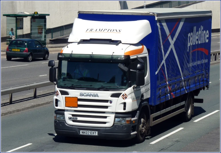 truck going down road in busy city with other vehicles